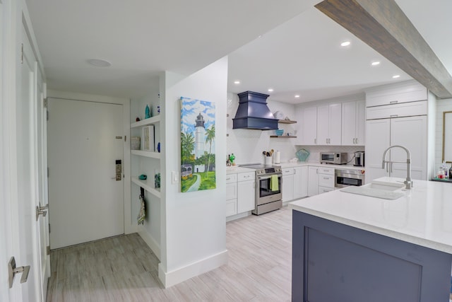 kitchen with open shelves, light countertops, custom exhaust hood, stainless steel appliances, and a sink