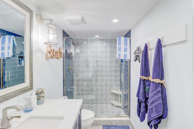 bathroom featuring recessed lighting, a stall shower, toilet, and vanity