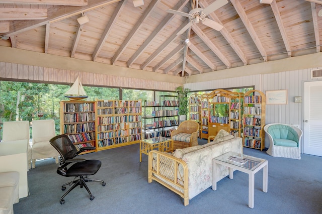 living area featuring visible vents, carpet floors, vaulted ceiling with beams, and bookshelves