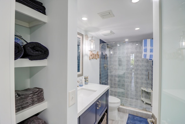 bathroom featuring vanity, toilet, recessed lighting, and a stall shower