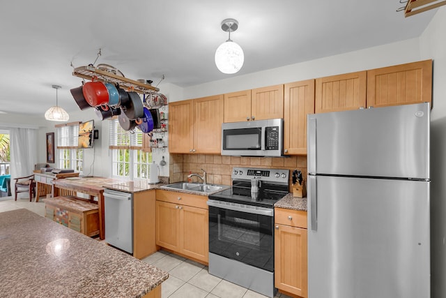 kitchen featuring light tile patterned floors, a sink, appliances with stainless steel finishes, tasteful backsplash, and pendant lighting