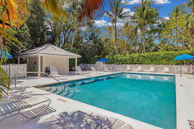 pool with a patio area and fence