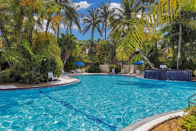 pool with a patio area and fence