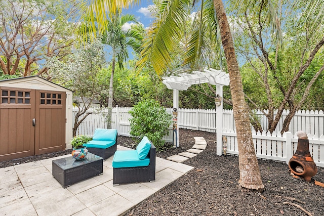 view of patio / terrace with an outbuilding, a storage unit, a fenced backyard, and a pergola