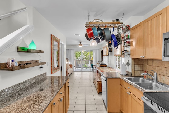 kitchen with visible vents, a sink, stainless steel appliances, backsplash, and light tile patterned flooring