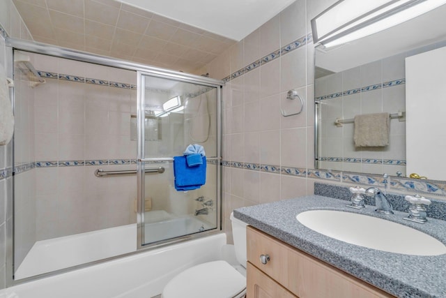 201 E Ocean Dr Unit 211, Key Colony, FL 33051 - bathroom with tile walls, vanity, shower / bath combination with glass door, and toilet