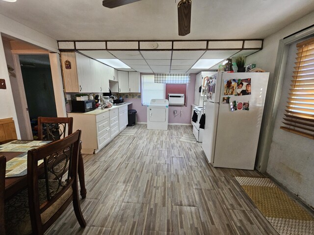 kitchen featuring white refrigerator, ceiling fan, washer and clothes dryer, light hardwood / wood-style floors, and a drop ceiling