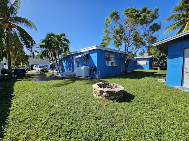 exterior space featuring cooling unit and an outdoor fire pit