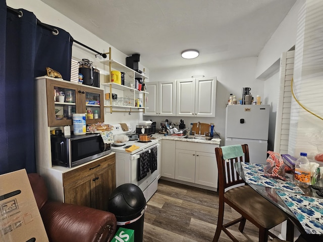 kitchen featuring white cabinetry, white appliances, dark hardwood / wood-style floors, and sink