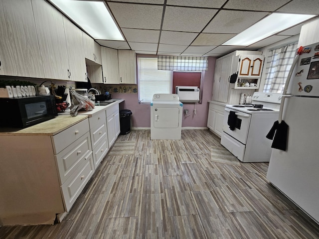 kitchen featuring washer / clothes dryer, white appliances, a center island, and light wood-type flooring