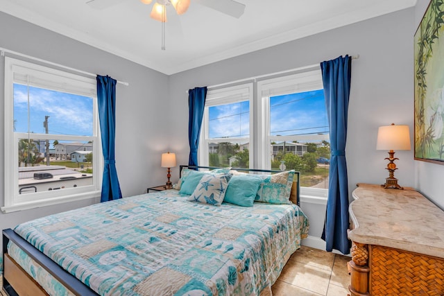 bedroom with crown molding, light tile patterned floors, and ceiling fan