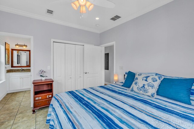 tiled bedroom with sink, crown molding, ceiling fan, ensuite bathroom, and a closet