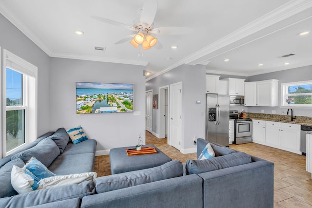 tiled living room with crown molding, ceiling fan, and sink