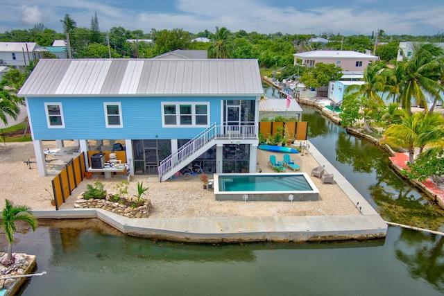 rear view of house featuring a patio and a water view