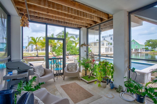 sunroom / solarium featuring a water view