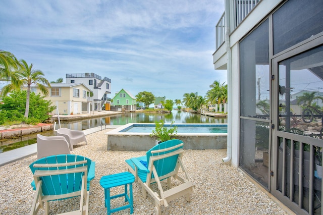 view of patio / terrace featuring an in ground hot tub and a water view