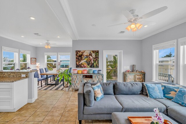 tiled living room with ornamental molding and ceiling fan