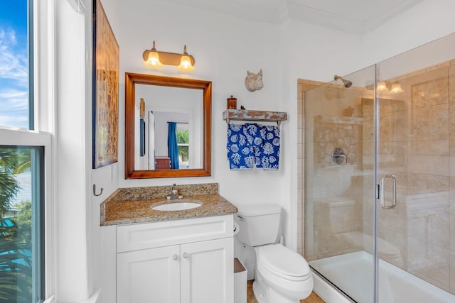 bathroom with vanity, ornamental molding, toilet, and walk in shower