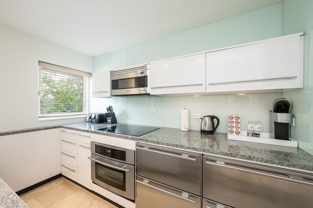 1401 Simonton St Unit 20, Key West, FL 33040 - kitchen featuring stone counters, stainless steel appliances, light tile patterned floors, and white cabinets