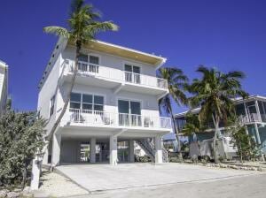 view of front of house featuring a carport, concrete driveway, and a balcony