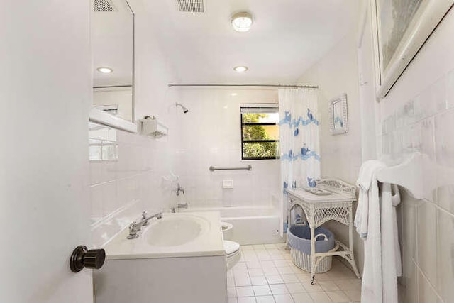 full bathroom with shower / tub combo with curtain, toilet, tile patterned flooring, and tile walls