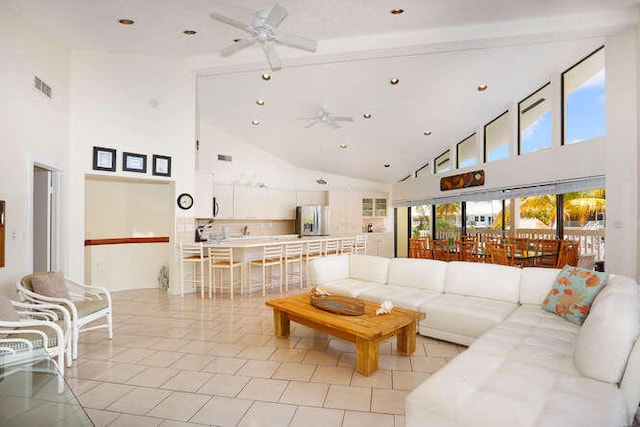 living room featuring beamed ceiling, high vaulted ceiling, and ceiling fan