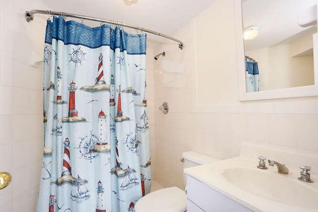 bathroom with tile walls, vanity, toilet, and a shower with shower curtain