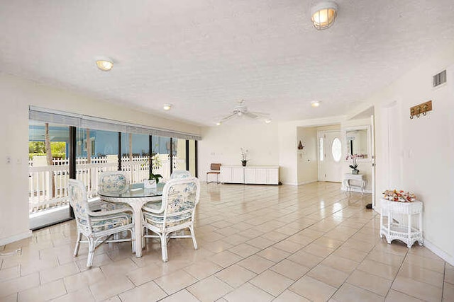 dining space featuring ceiling fan, a textured ceiling, and light tile patterned floors