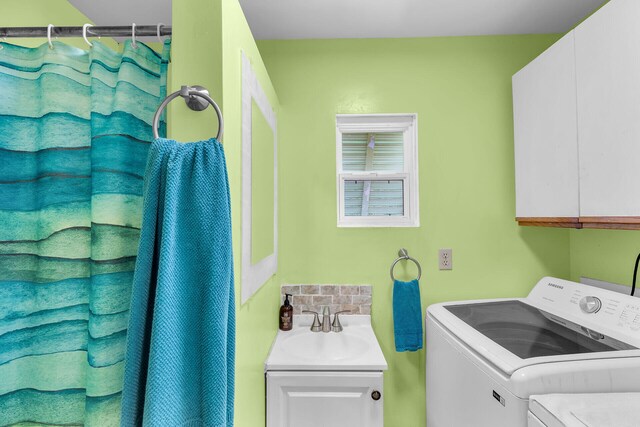 washroom with cabinets, separate washer and dryer, and sink