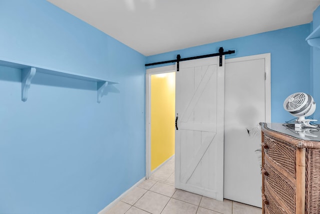 interior space with a barn door and light tile patterned floors