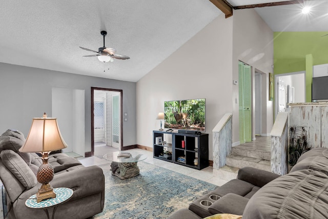 living room featuring lofted ceiling with beams, ceiling fan, light tile patterned floors, and a textured ceiling