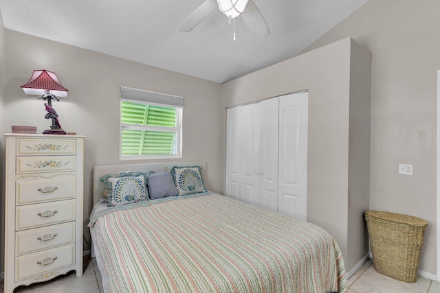 tiled bedroom featuring ceiling fan and a closet