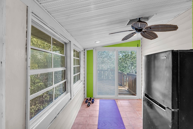 unfurnished sunroom featuring vaulted ceiling, plenty of natural light, and ceiling fan