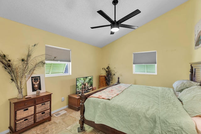 bedroom featuring ceiling fan, vaulted ceiling, and a textured ceiling