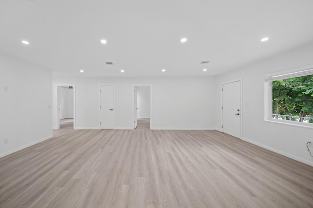 unfurnished living room featuring recessed lighting, light wood-style flooring, and baseboards