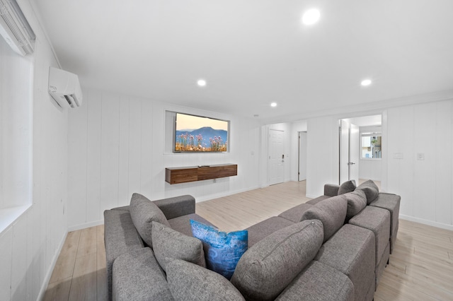 living room with a wall mounted AC, light wood-type flooring, and recessed lighting