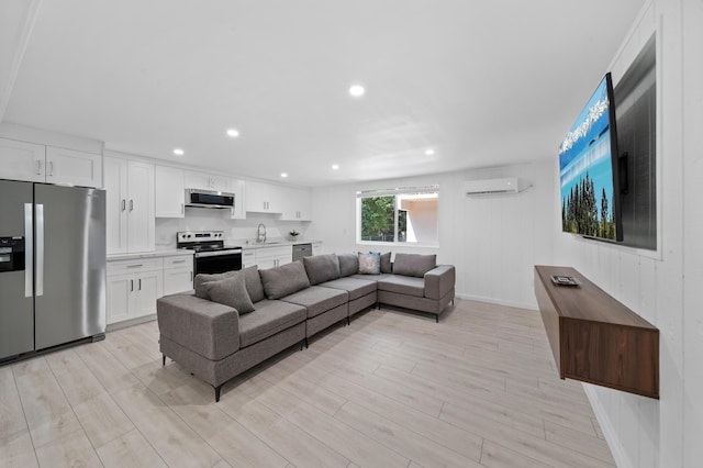 living room featuring a wall mounted air conditioner, recessed lighting, and light wood-style floors