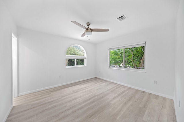 unfurnished room with light wood finished floors, baseboards, and a ceiling fan