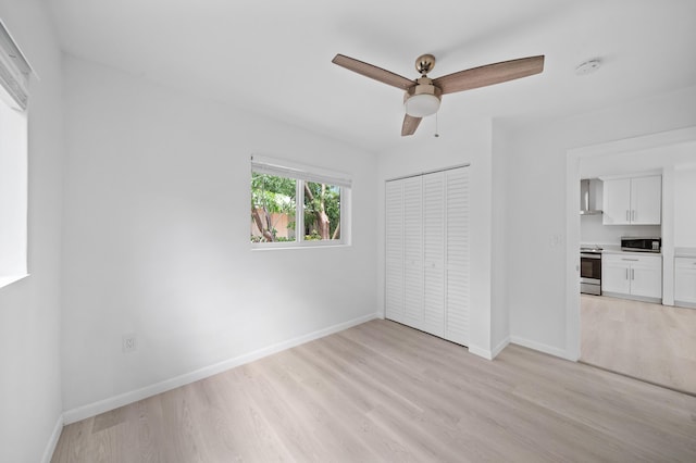 unfurnished bedroom featuring light wood-style flooring, baseboards, a closet, and a ceiling fan