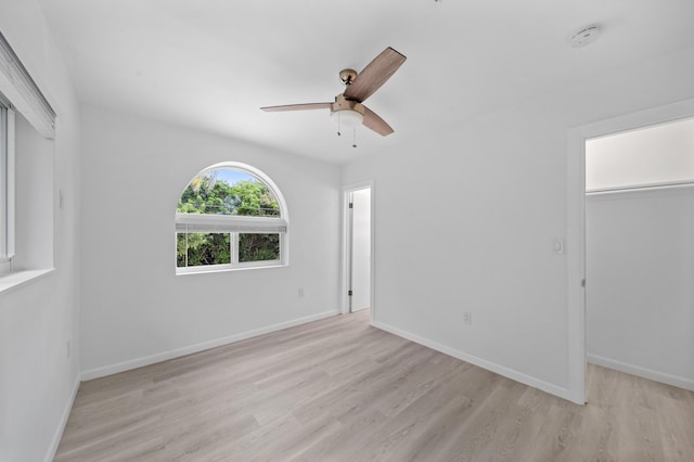 unfurnished room with ceiling fan, light wood-type flooring, and baseboards