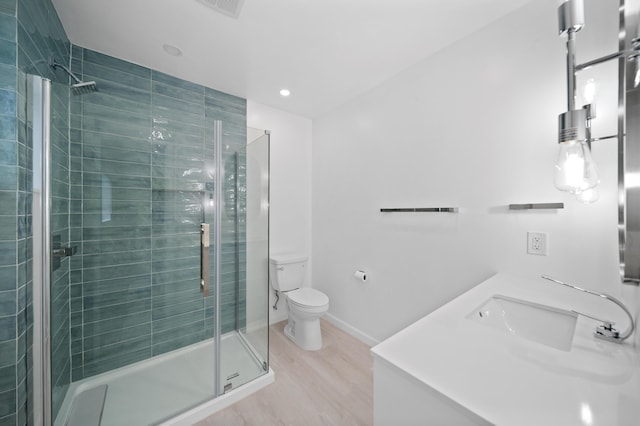 bathroom featuring a shower stall, toilet, wood finished floors, a sink, and recessed lighting