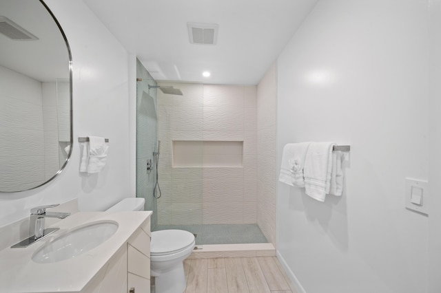 bathroom featuring toilet, walk in shower, and vanity