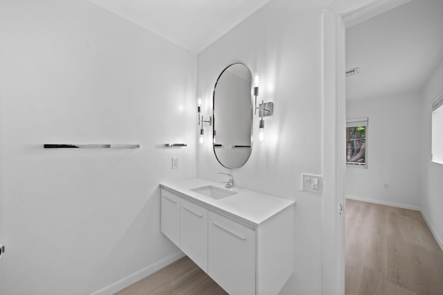 bathroom featuring wood finished floors, baseboards, and vanity