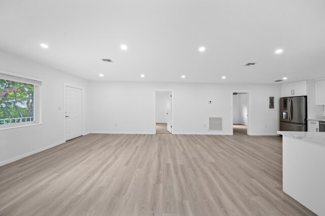 unfurnished living room featuring recessed lighting, baseboards, and light wood finished floors