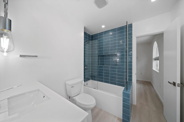 full bathroom with wood finished floors, toilet, washtub / shower combination, recessed lighting, and a sink