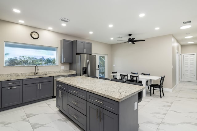 kitchen featuring gray cabinetry, marble finish floor, a sink, and appliances with stainless steel finishes