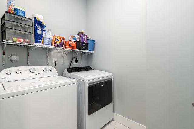 laundry room featuring laundry area, washing machine and clothes dryer, and baseboards
