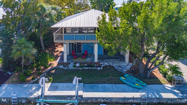 exterior space with a balcony, a front yard, and a patio area