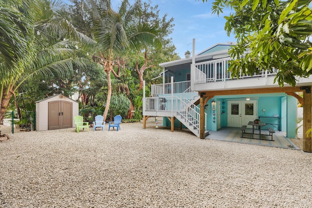 rear view of property featuring a storage shed and a patio area