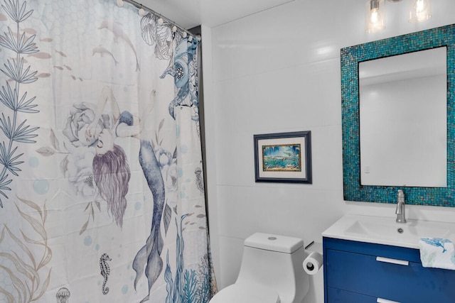 bathroom with tile walls, vanity, curtained shower, and toilet